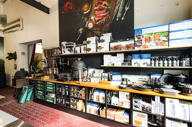 Zubehörwand mit Grillbesteck, Gusseisenpfannen, Pflegeprodukten und Grillzubehör