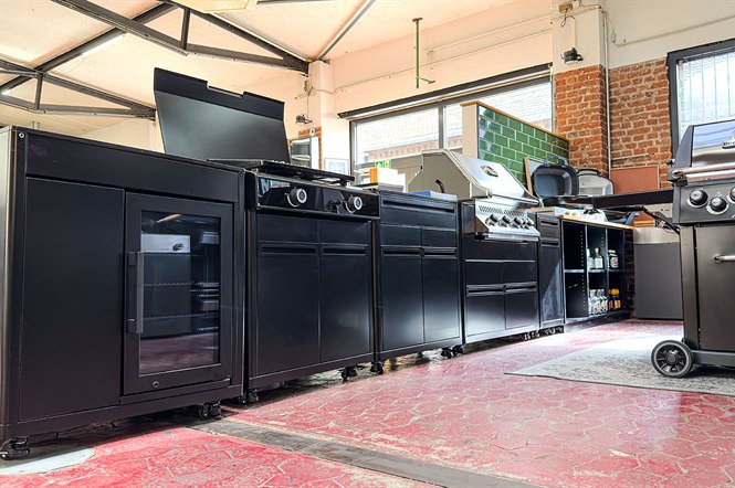 Schwarze Outdoorküchen-Module mit Kühlschrank, Kochfeld und Einbaugrill in Reihe aufgestellt