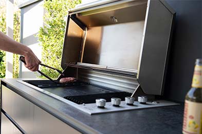 Fleisch wird auf einen Grill gelegt