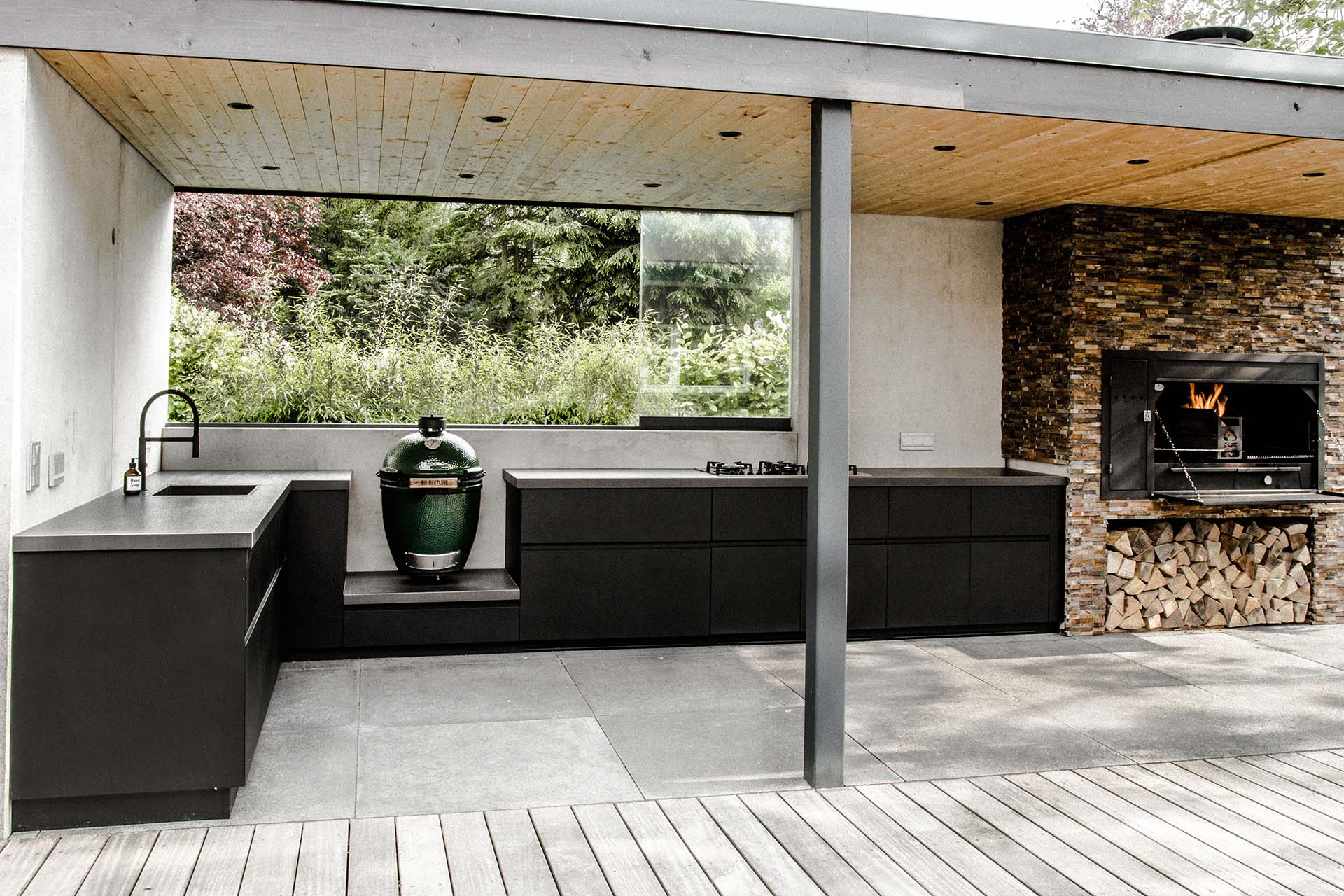Geräumige Outdoorküche neben einem Holzofen