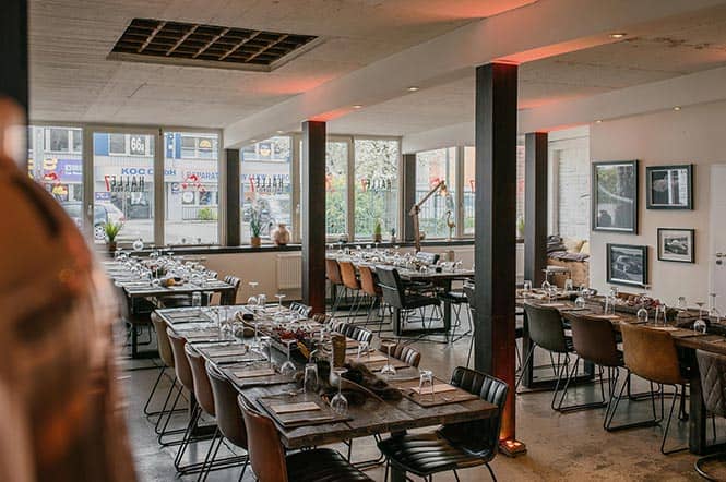 Raumansicht Halle 7 für Grillevents in Düsseldorf: Vier eingedeckte Tische mit Platz für je 10 Personen