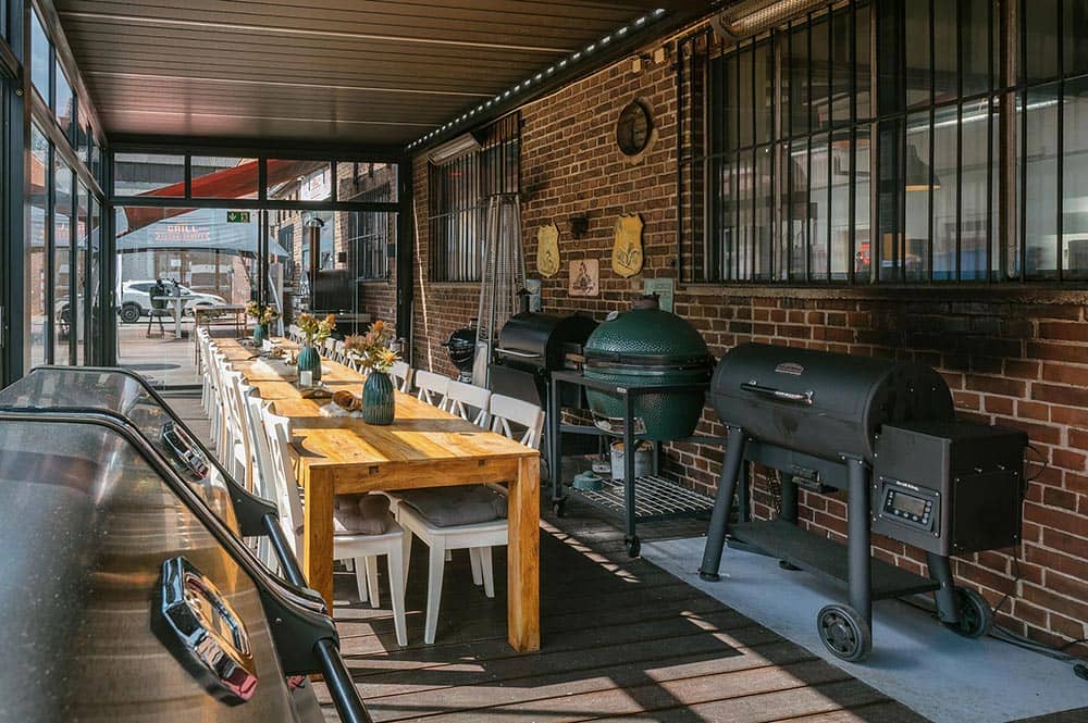 Wintergarten an der Halle 25 im Grillfachgeschäft Düsseldorf: Lange Tafel mit floraler Deko und Grill-Ausstellung