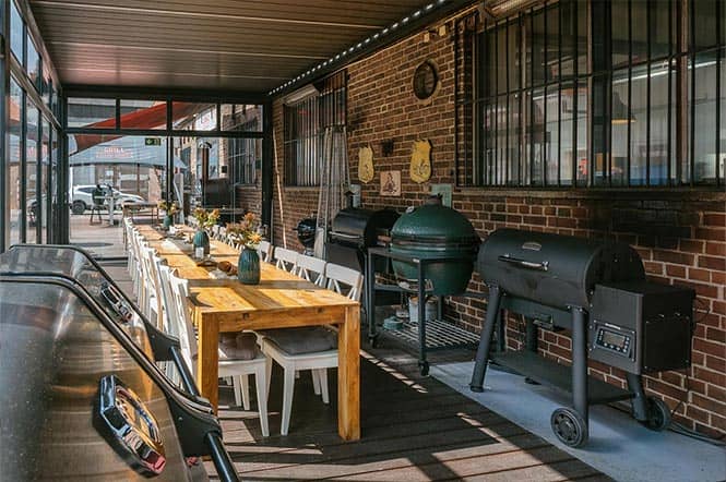 Wintergarten an der Halle 25 im Grillfachgeschäft Düsseldorf: Lange Tafel mit floraler Deko und Grill-Ausstellung