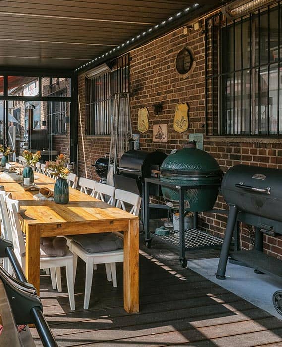 Wintergarten an der Halle 25 im Grillfachgeschäft Düsseldorf: Lange Tafel mit floraler Deko und Grill-Ausstellung